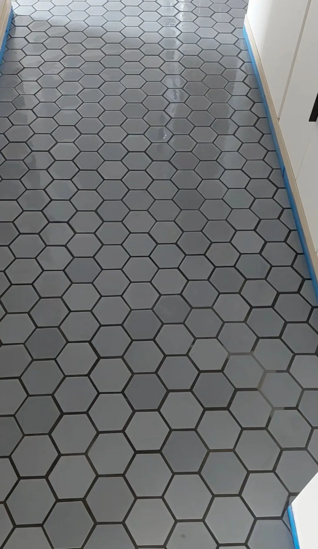 Gray hexagon tile floor installed in a hallway