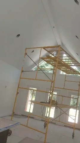Scaffolding set up in a vaulted room being painted